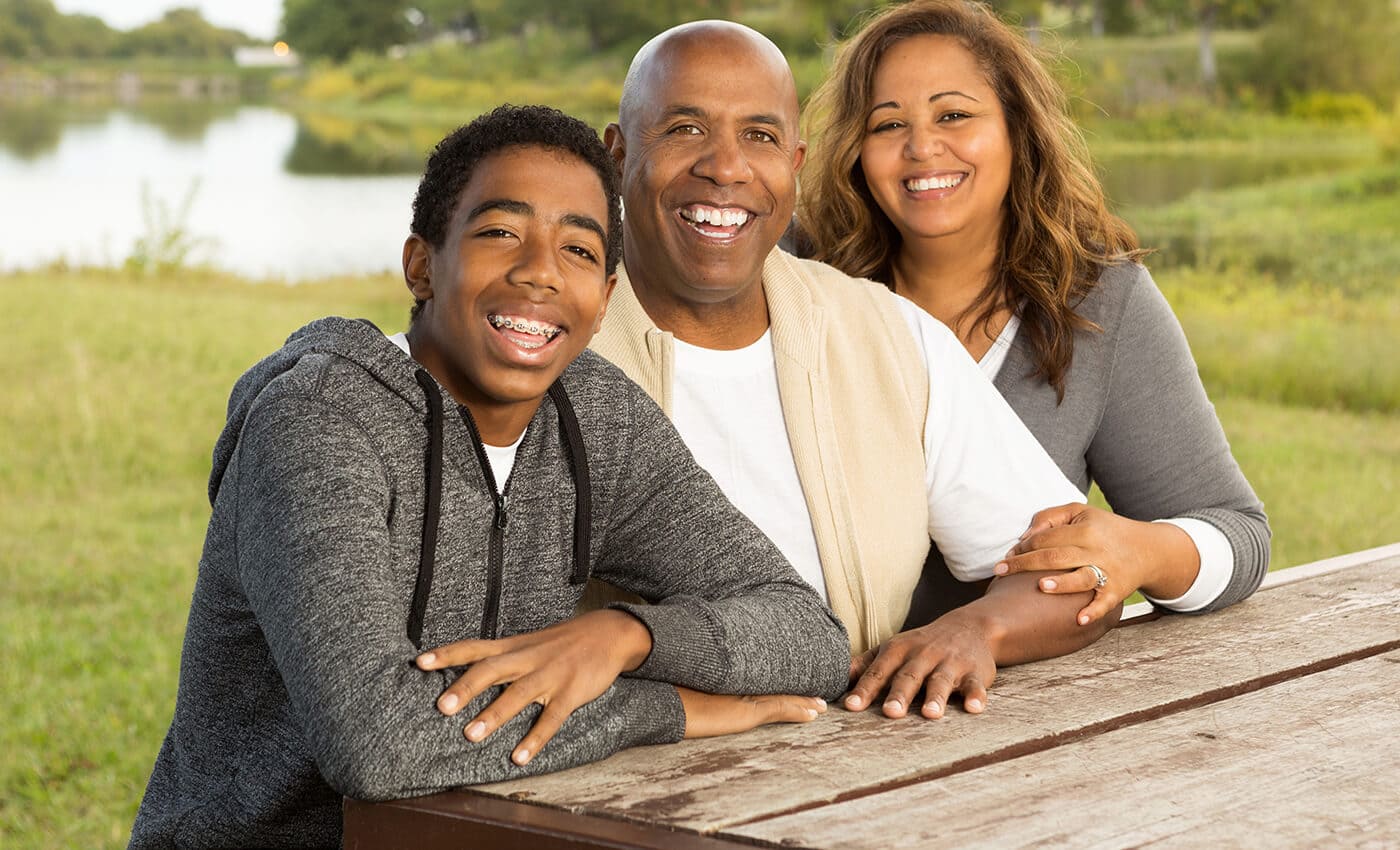 parents and son with braces smiling